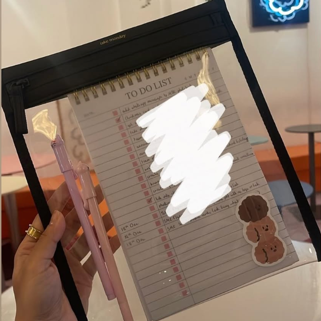 Hand holding a pen with a light effect over a to-do list on a lightbox.